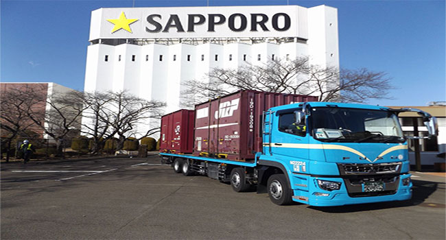 サッポロビールの千葉～仙台工場間輸送の一部を鉄道輸送に切り替えモーダルシフトを推進し、年間のCO₂排出量を約44t削減。さらに倉庫内作業自動化によるドライバーの待機時間を削減。